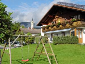 un parque infantil con un columpio en un patio en Ferienhaus Kössel, en Pfronten