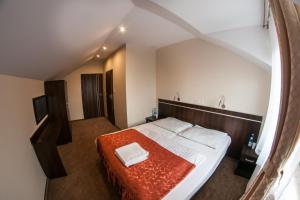 um quarto com uma cama grande e um cobertor vermelho em Hotel E7 em Radom