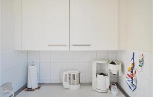 eine Küche mit weißen Schränken und weißen Geräten in der Unterkunft Ferienhaus Zum Anleger G in Hohen Wieschendorf