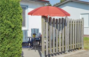 a wooden fence with a table with an umbrella at Holiday Home Zum Anleger I in Hohen Wieschendorf