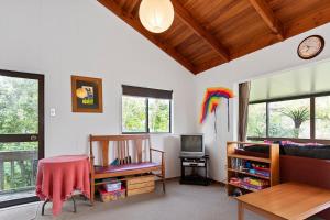 un soggiorno con un divano e un tavolo di Riverview Retreat - Cooks Beach Holiday Home a Cooks Beach