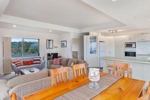a kitchen and living room with a table and chairs at White Island Views - Ohope Holiday Home in Ohope Beach