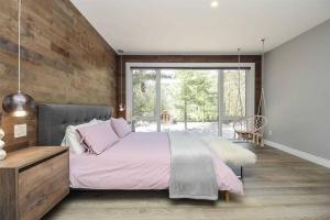 a bedroom with a large bed and a large window at Chic & luxurious villa with outdoor sauna in Wymbolwood Beach