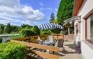 eine Terrasse mit einem Tisch, Stühlen und einem Sonnenschirm in der Unterkunft Ferienhaus Lindenberg R in Klein Nemerow