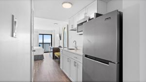 a kitchen with a refrigerator and a sink at Grande Beach Resort in Myrtle Beach