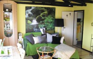 a living room with a green couch and a painting at 1 Bedroom Awesome Home In Mustin in Mustin