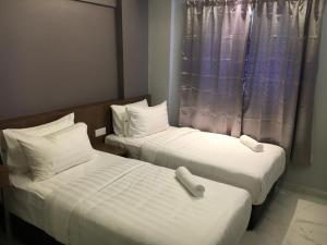 two beds in a hotel room with a window at Festival Boutique Hotel - Damai Complex in Kuala Lumpur