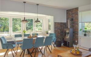 a dining room with a table and chairs and a fireplace at Nice Home In Cadenberge With Sauna in Cadenberge