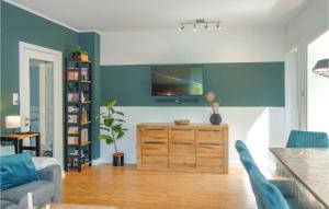 a living room with a tv on a blue wall at Nice Home In Cadenberge With Sauna in Cadenberge