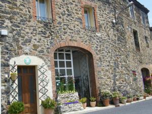 un edificio de piedra con puerta y macetas en Gîte Les Mimosas en Prugnanes