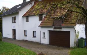 une grande maison blanche avec un grand garage dans l'établissement Lovely Home In Medebach-ddinghausen With Kitchen, à Medebach