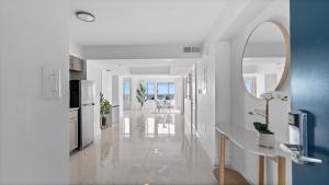 a white hallway with a kitchen and a mirror at Grande Beach Resort in Myrtle Beach