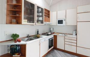 eine Küche mit weißen Schränken und einem Waschbecken in der Unterkunft Strandblick 29 in Schönhagen