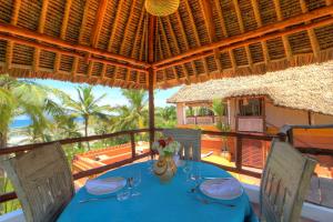 una mesa con un mantel azul en el balcón en Swahili House, en Tiwi