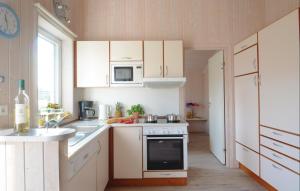 a kitchen with white cabinets and a stove top oven at Strandpark 14 in Schönhagen