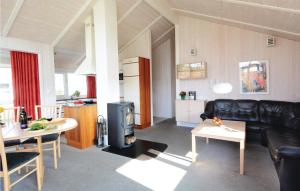 a living room with a black leather couch and a stove at Strandpark 22 in Schönhagen