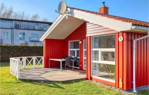 einem roten Schuppen mit einer Terrasse und einem Tisch in der Unterkunft Strandpark 1 in Schönhagen