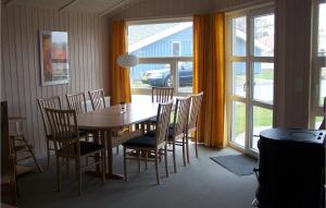 ein Esszimmer mit einem Tisch, Stühlen und einem Fenster in der Unterkunft Strandpark 19 in Schönhagen