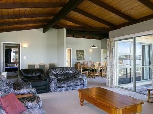 a living room with couches and a table and a dining room at Golders Heights - Taupo Holiday Home in Taupo