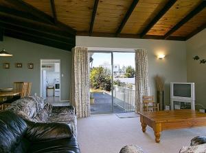 a living room with a couch and a wooden table at Golders Heights - Taupo Holiday Home in Taupo