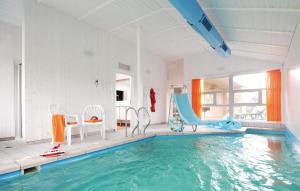 einen Pool mit Rutsche und Stühlen in einem Zimmer in der Unterkunft Strandpark 20 in Schönhagen