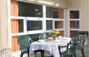 ein Tisch auf einer Veranda mit Stühlen und Blumen darauf in der Unterkunft Strandpark 20 in Schönhagen