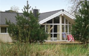 une petite maison avec une terrasse couverte et 2 chaises dans l'établissement Strandblick 4 - Dorf 1, à Travemünde