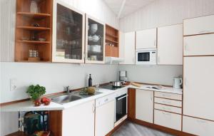 a kitchen with white cabinets and a sink at Strandblick 12 - Dorf 1 in Travemünde