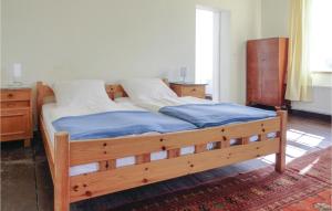Schlafzimmer mit einem Holzbett mit blauer Bettwäsche in der Unterkunft Amazing Apartment In Waabs With 1 Bedrooms And Wifi in Waabs