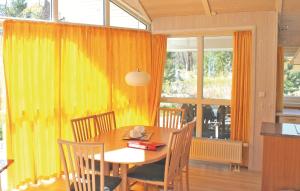 ein Esszimmer mit einem Tisch und einem gelben Vorhang in der Unterkunft Strandblick 8 - Dorf 1 in Travemünde