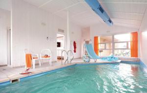 a pool with a slide and chairs in a room at Strandblick 21 - Dorf 1 in Travemünde