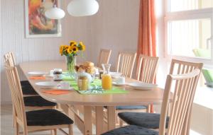 a dining room table with a vase of flowers on it at Strandblick 16 - Dorf 1 in Travemünde