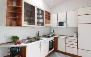 eine Küche mit weißen Schränken und einem Waschbecken in der Unterkunft Strandblick 9 - Dorf 1 in Travemünde