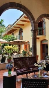 an outdoor patio with a bench and an umbrella at Casa aroma de café, en el corazón de Coatepec. in Coatepec