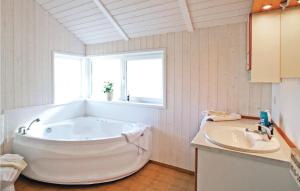 a white bathroom with a tub and a sink at Strandblick 19 - Dorf 1 in Travemünde