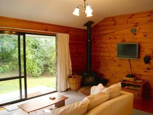 uma sala de estar com um sofá, uma televisão e uma lareira em Puka Lodge Front dwelling - Pukawa Bay Home em Kuratau