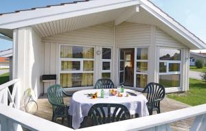 a patio with a table and chairs on a deck at Friedrichskoog-strandpark 13 in Friedrichskoog