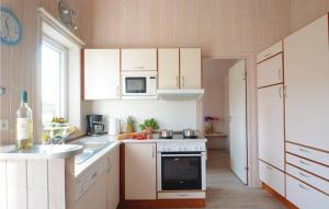 a kitchen with white cabinets and a sink and a stove at Friedrichskoog-strandpark 13 in Friedrichskoog