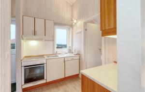 a kitchen with white cabinets and a sink and a stove at Friedrichskoog-Strandpark 18 in Friedrichskoog