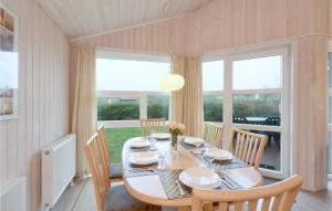 a dining room with a table and chairs and windows at Friedrichskoog-Strandpark 18 in Friedrichskoog