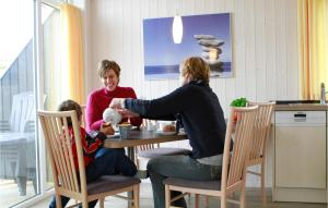a woman is sitting at a table with a child at Friedrichskoog-Deichblick 7 in Friedrichskoog +8 photos