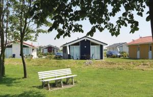 a park bench in front of a row of houses at Friedrichskoog-Deichblick 8 in Friedrichskoog