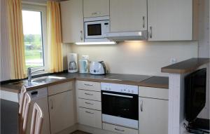 a kitchen with a sink and a stove top oven at Friedrichskoog-Deichblick 1 in Friedrichskoog +15 photos