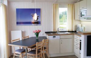 eine Küche mit einem Tisch, Stühlen und einem Waschbecken in der Unterkunft Friedrichskoog-deichblick 1 in Friedrichskoog