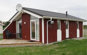 a red and white building with a deck at Friedrichskoog-Deichblick 1 in Friedrichskoog