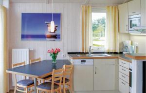 eine Küche mit einem Tisch, Stühlen und einem Waschbecken in der Unterkunft Friedrichskoog-deichblick 9 in Friedrichskoog