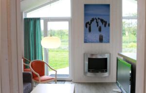 a living room with a tv and a window at Friedrichskoog-Deichblick 10 in Friedrichskoog +9 photos