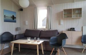 ein Wohnzimmer mit einem Sofa, Stühlen und einem Tisch in der Unterkunft Friedrichskoog-deichblick 14 in Friedrichskoog
