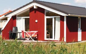 a red house with a table in front of it at Friedrichskoog-Deichblick 14 in Friedrichskoog