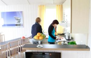 two people standing in a kitchen preparing food at Friedrichskoog-Deichblick 11 in Friedrichskoog